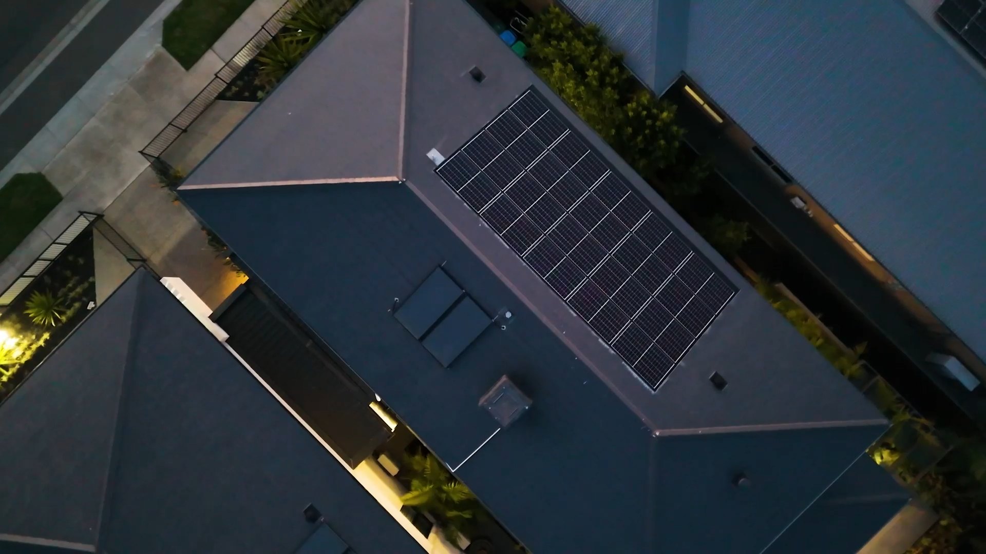 Drone view over a rooftop at dusk, a still from a property film